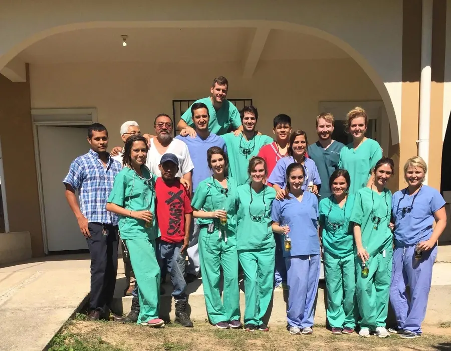 The 2016 mission team in green and blue scrubs outside a clinic building in Mexico.