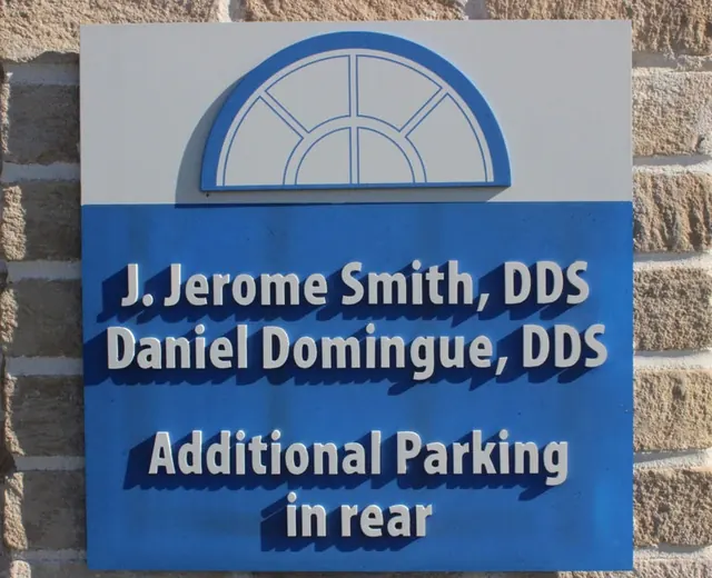 The practice sign outside Building 2: J. Jerome Smith, DDS, Daniel Domingue, DDS, additional parking in rear.